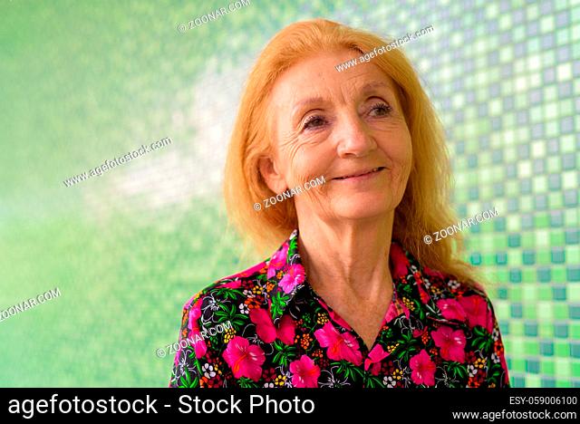 Portrait of a senior woman with blonde hair outdoors during summer