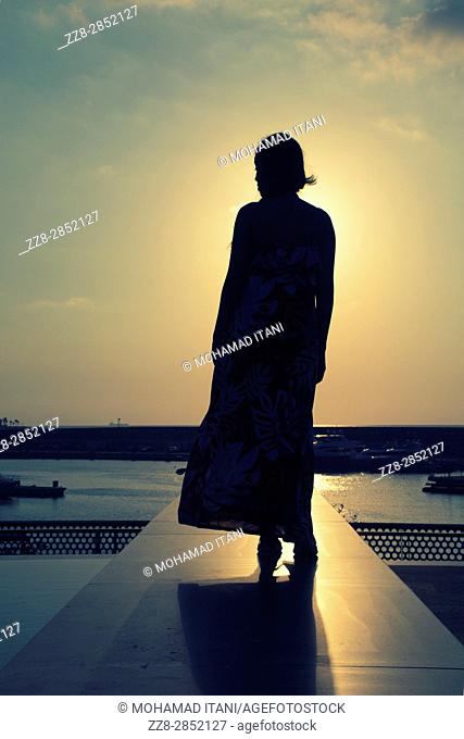 Full length silhouette of a woman at sunset