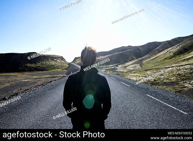 Man standing with hands in pockets at Kaldidalur highway, Iceland