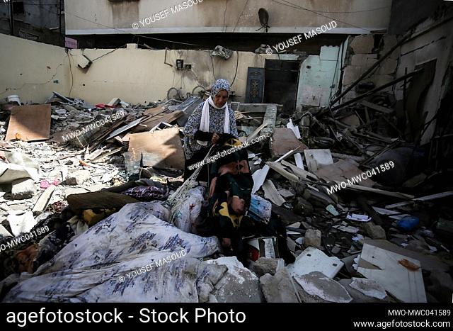 Palestinians inspect the damage at a destroyed house that was hit by an Israeli air strike in the southern Gaza Strip, amid the escalation of violence between...
