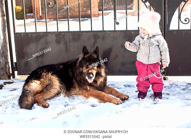 Little girl talking with her dog on winter walk