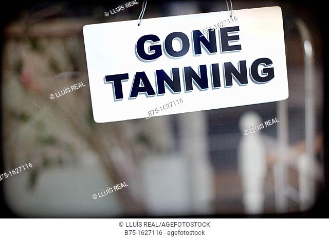 closed sign in a business, gone tanning