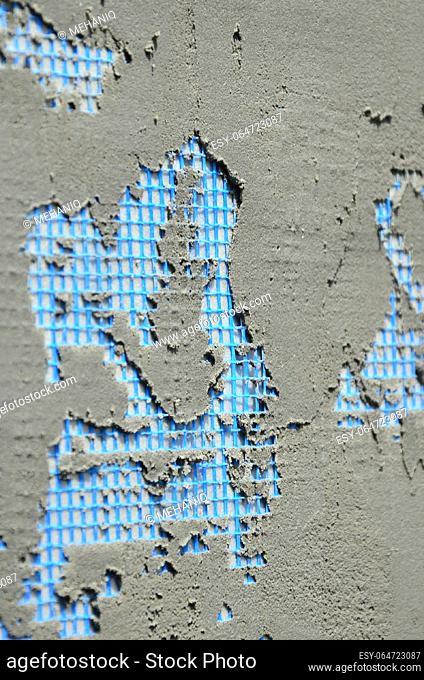 The texture of the wall, covered with gray foam polystyrene plates, covered with a blue reinforcing mesh and covered with a mixture for gluing it