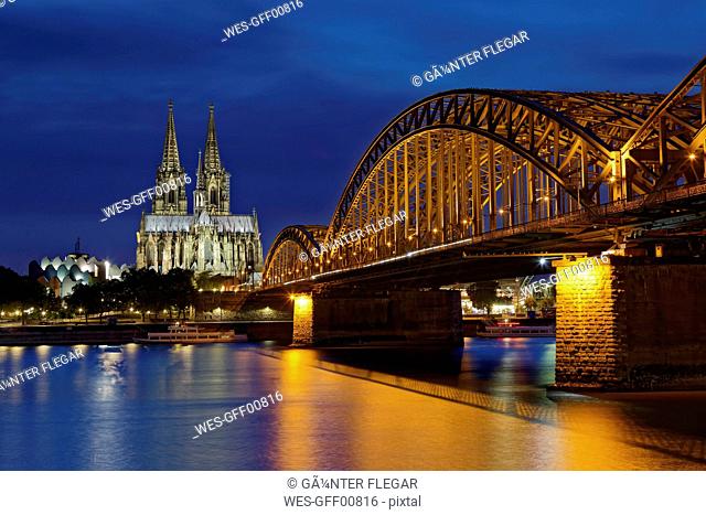 Germany, Cologne, lighted Cologne Cathedral and Hohenzollern Bridge