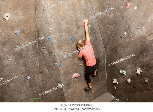 young woman exercising at indoor climbing gym