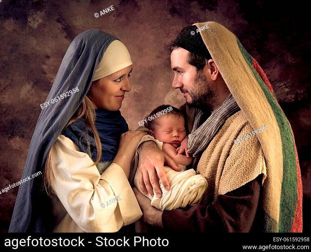 Live Christmas nativity scene with the real parents of a 9 days old newborn baby boy, swaddled as baby Jesus