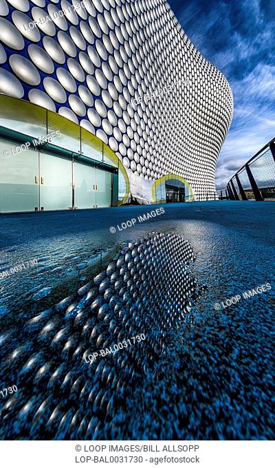 The Selfridges building reflected in a puddle