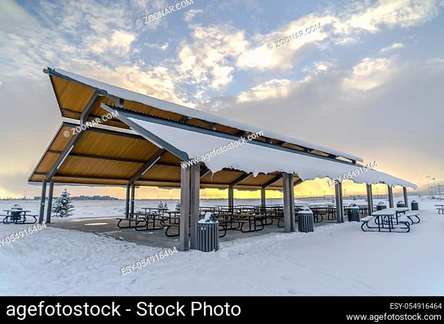 Eeating area with snowy roof on a frosty landscape. An eating area with snow covered roof in Eagle Mountain, Utah. The area stands against a frosty white...