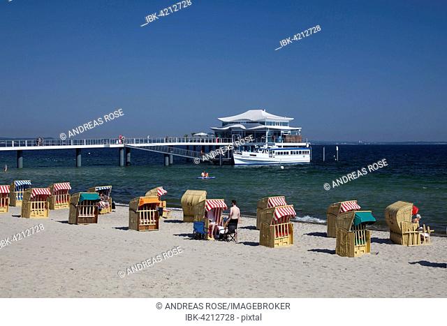 Beach chairs on Timmendorfer beach with Seeschlösschenbrücke bridge and Japanese teahouse, Bay of Lübeck, Baltic Sea, Schleswig-Holstein, Germany
