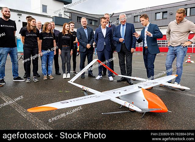 09 August 2023, Bavaria, Erlangen: Adrian Sauer (2nd from right), from the ""Evolonic"" research project, explains details of the project drone for early...