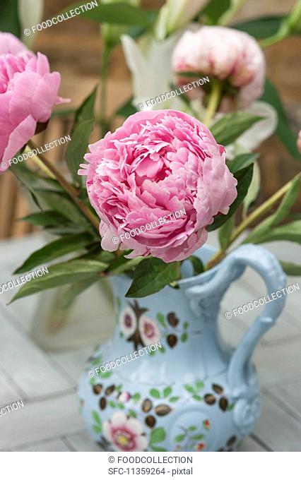 A pink peony in a painted porcelain vase