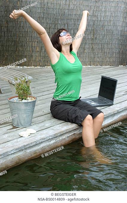 woman with laptop at pond