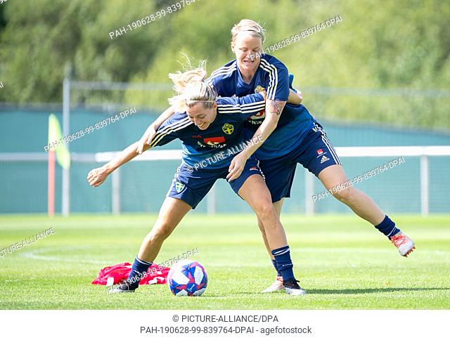 28 June 2019, France (France), Fougeres: Football, women: World Cup, national team, Sweden, training: Linda Sembrant (l) and Nilla Fischer fight for a ball for...