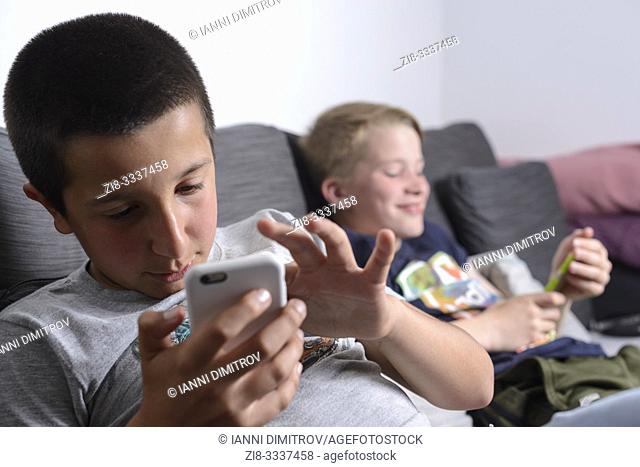 Boys watching online videos on their mobile phones