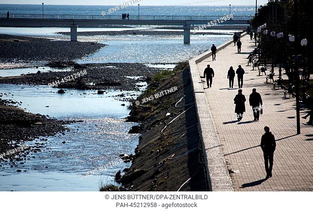 People walk along a watercourse near the Olympic Park in Sochi, Russia, 17 December 2013. Sochi will host the Winter Olympic Games from 07 to 23 February 2014