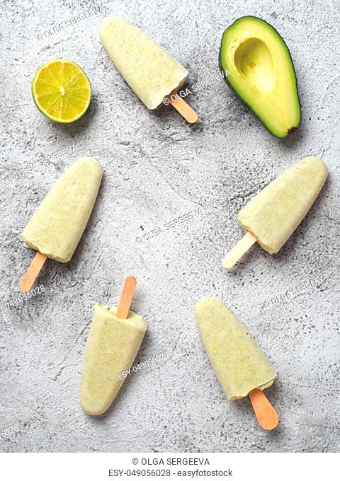 Homemade raw vegan avocado lime popsicle. Sugar-free, non-dairy green ice cream on gray background. Copy space. Top view