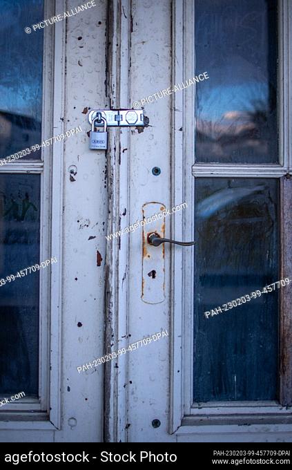 PRODUCTION - 17 January 2023, Mecklenburg-Western Pomerania, Sassnitz: A door on the listed former cultural center and cinema ""Haus Stubnitz"" is secured with...