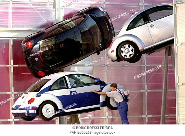 On 16.5.2000, a worker carefully removes the protective foil from a new Volkswagen Beetle (""New Beetle"") on the outside facade of the Mexican pavilion on the...