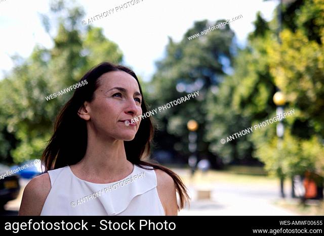 Smiling mature woman with long hair at park