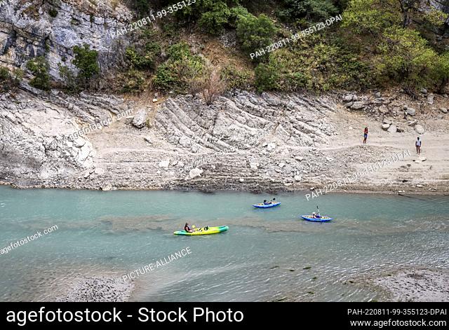 11 August 2022, France, Aiguines: Canoeists paddle into the Verdon Gorge at the Lac de Sainte-Croix reservoir during low water