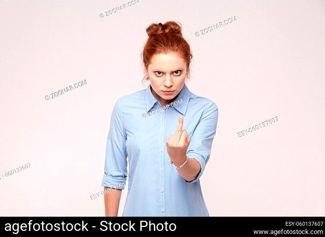 Bad emotions. Fuck sign. Redhead bussiness woman. Isolated on gray backgraund , studio shot