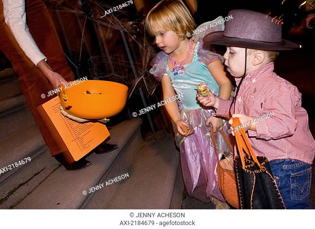 USA, New York State, Children in Halloween costumes receiving sweets; New York City