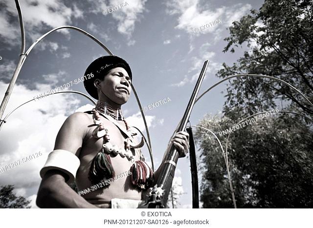 Naga tribesman holding a rifle during the annual Hornbill Festival at Kisama, Kohima, Nagaland, India