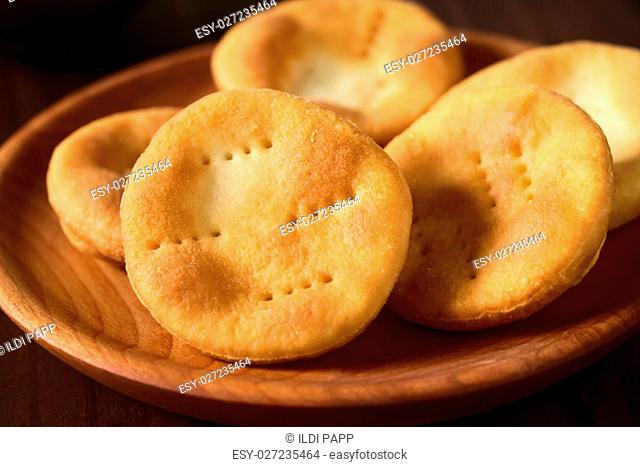 Traditional Chilean Sopaipilla fried pastries made of a bread-like leavened dough served on wooden plate, photographed with natural light (Selective Focus