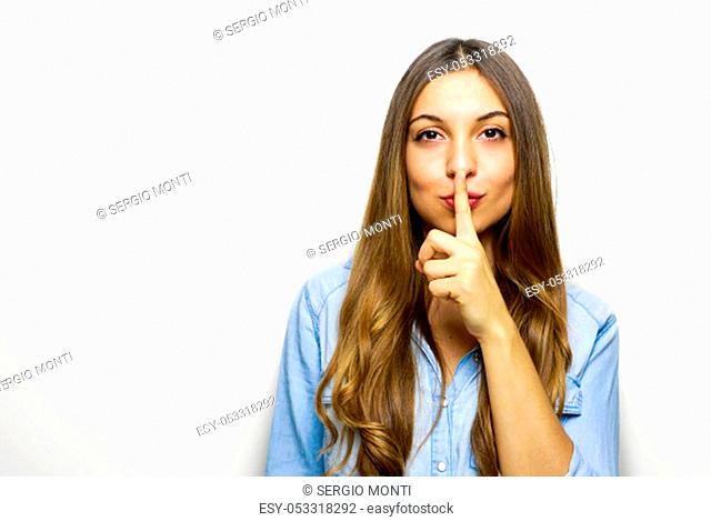 It's a secret! Shut your mouth. Finger on lips. Portrait of pretty cheerful female making shush or shh gesture with index finger over mouth