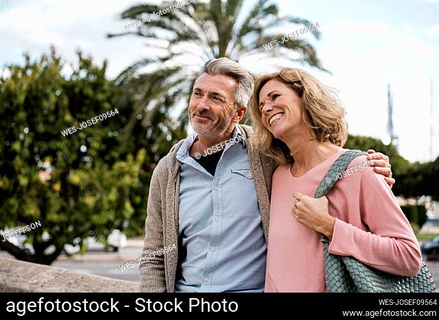 Smiling man with arm around with woman