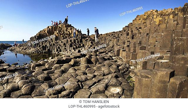 Northern Ireland, County Antrim, Giants Causeway, Tourists exploring the interlocking basalt columns of the Giants Causeway