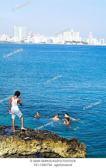 Cuban boys swimming in the Caribbean sea along the Malecón in Havana, Cuba