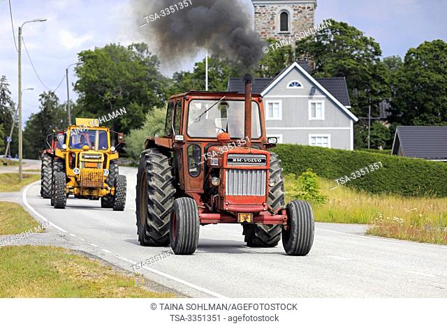 Kimito, Finland. July 6, 2019. Volvo BM tractors, red 810 first, on Kimito Tractorkavalkad, annual tractor parade through the small town