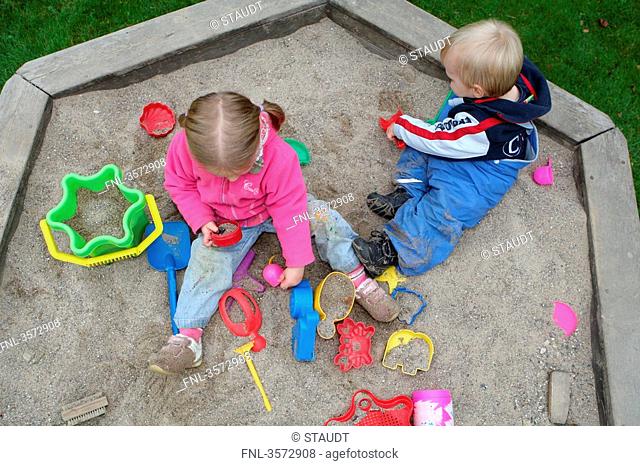 Two kids playing in sandbox