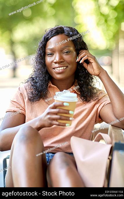 african woman with coffee and backpack in city