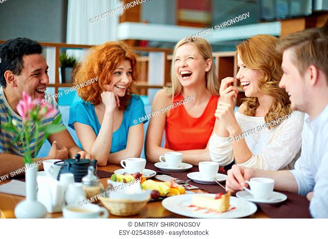 Joyful friends spending time in cafe