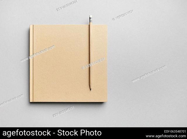 Blank closed book and pencil on gray paper background. Responsive design template. Copy space for text. Flat lay