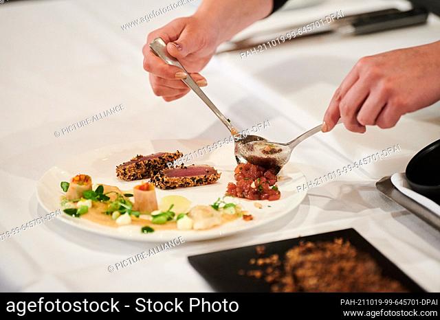 18 October 2021, Berlin: A waitress places tuna tartare on a plate at the International ""L'Art de Vivre Competition"" for service staff in restaurants and...