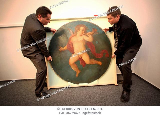 Chemist Franz Renz (R) and his brother antiquities dealer Josef Renz pack up the painting ""The Trumpetting Cherub"" at the campus of Johan-Gutenberg University...