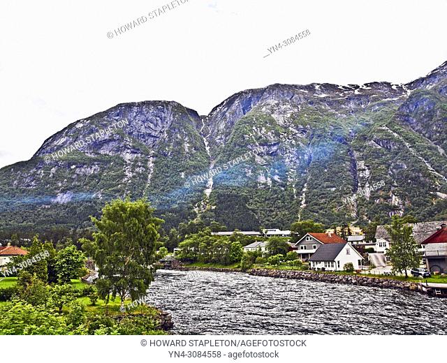 The Eio river runs through the village of Eidfjord, Norway. Mountains surround the town. The Eio river is only 1. 3 miles long and runs from Lake Eidfjord into...
