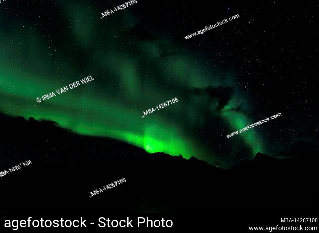 Northern Lights or Aurora Borealis dance over the fjord landscape