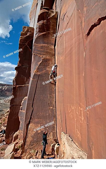 Man rock climbing a route called Amaretto Corner on Super Crack Buttress at Indian Creek Canyon in southern Utah