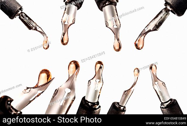 set from steel nibs with pink ink drops close up on dip pen isolated on white background
