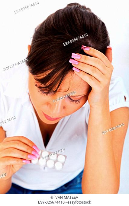 Young woman taking a pill isolated on white background