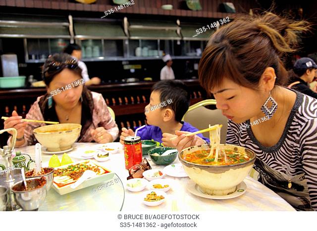 Customers in a restaurant having 'guoqiao mi xian' (Crossing the bridge noodles) a kind of rice noodle soup from Yunnan, Kunming, China