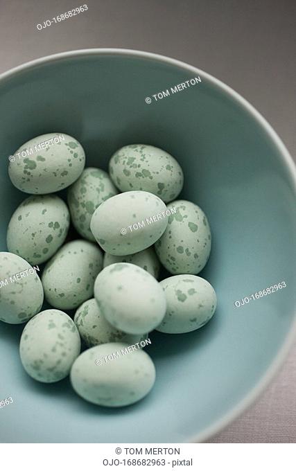 Close up of speckled blue candy eggs in bowl