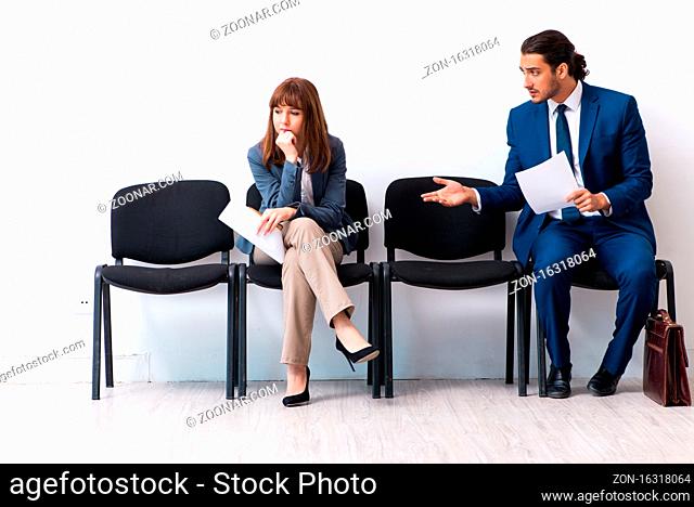 Businessman and businesswoman waiting for an interview at hall