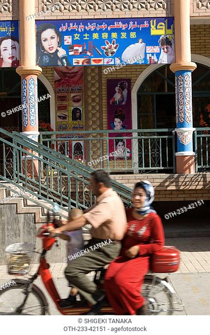 Uyghur couple on a scooter at Bazaar, Old town of Kashgar, Xinjiang Uyghur autonomy district, Silkroad, China