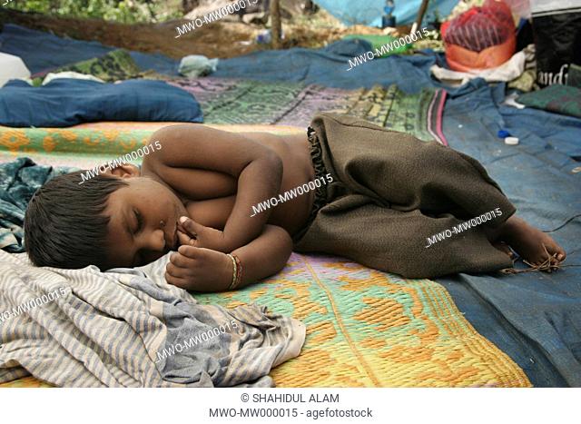 A child sleeps in a refugee tent set up near Trincomalee following the Indian Ocean tsunami in 2004 Sri Lanka January 3, 2005