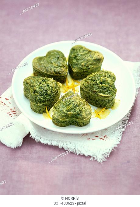 Heart-shaped spinach, orange zests and almond Flans
